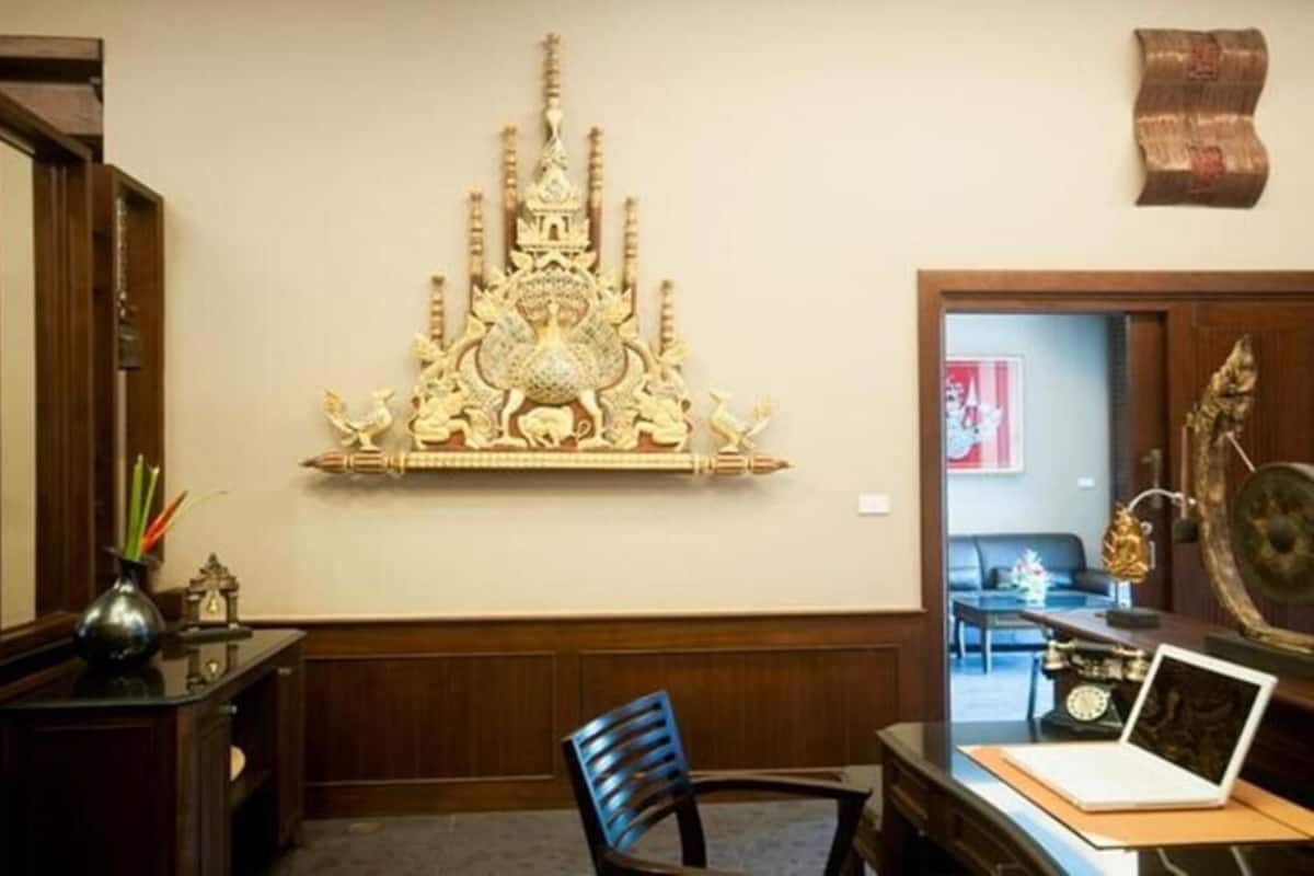A room with a desk, chair, and a decorative wall piece.
