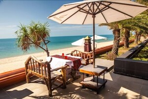 En la playa, sillas reclinables de playa, sombrillas, toallas de playa