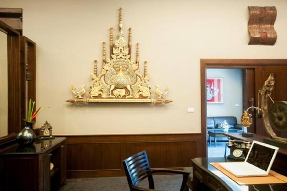 A room with a desk, chair, and a decorative wall piece.