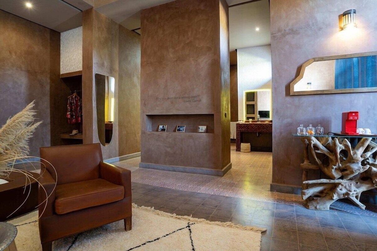 A modern interior with a leather sofa, a fireplace, a wooden coffee table, and a unique tree root design piece.