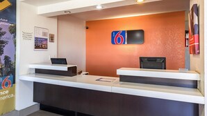 Ein Hotelrezeptionstresen mit digitaler Anzeige und zwei Computerarbeitsplätzen.