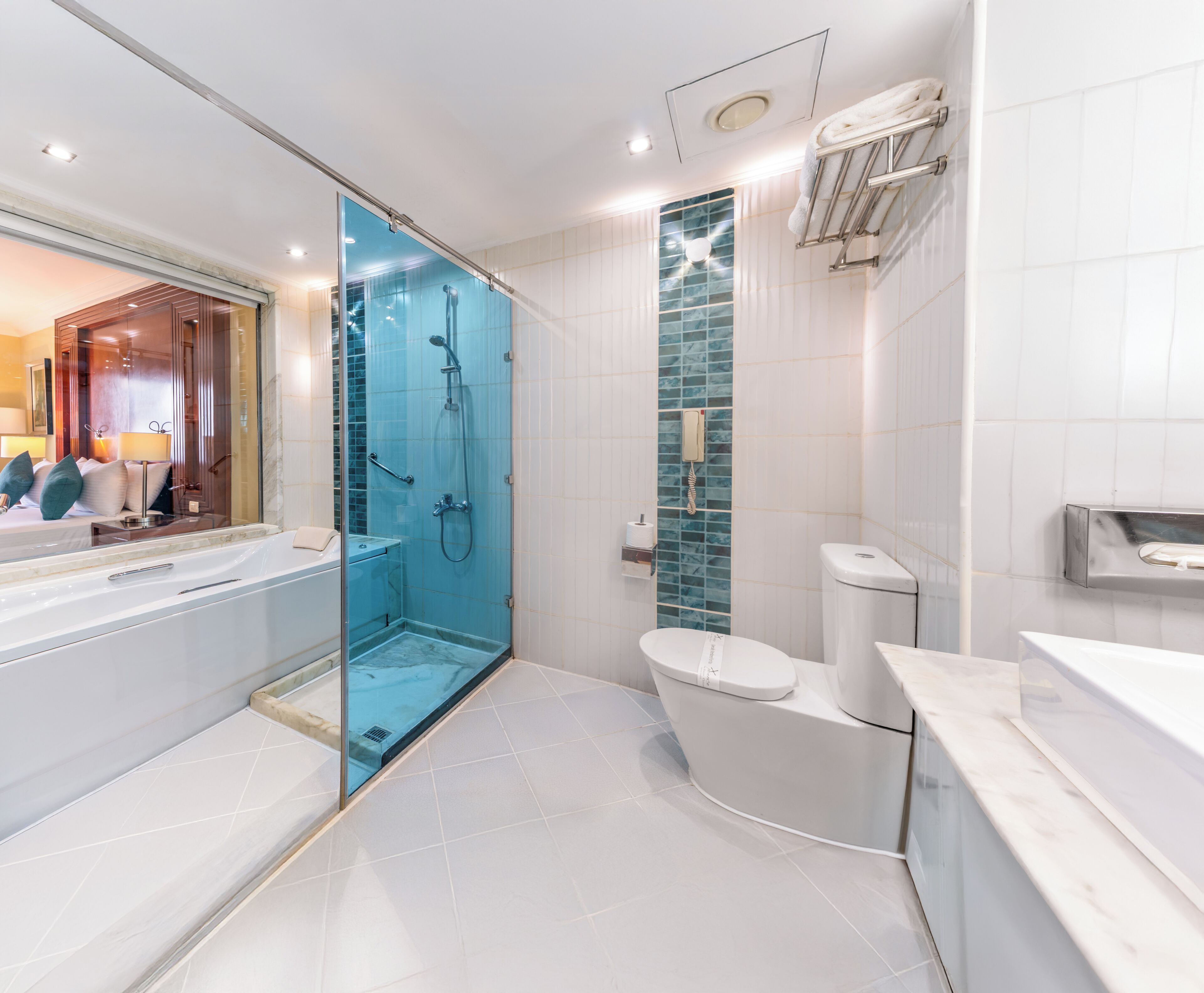 A modern bathroom with a glass-enclosed shower, a toilet, and a sink.