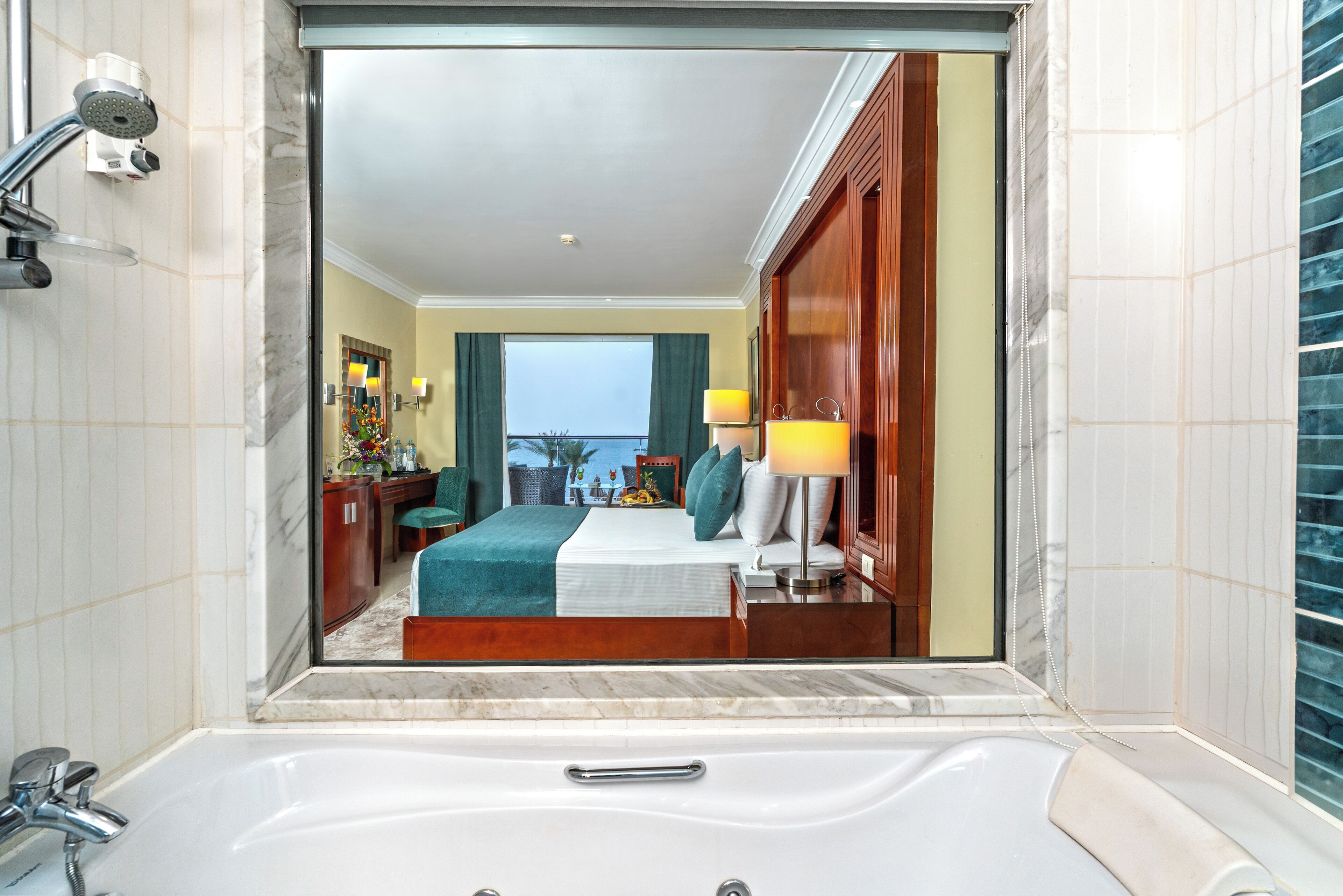 Une salle de bain d’hôtel avec une grande baignoire, une douche et un miroir.