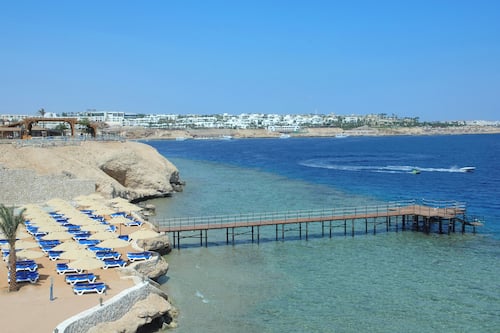Praia particular, areia branca, espreguiçadeiras, guarda-sóis