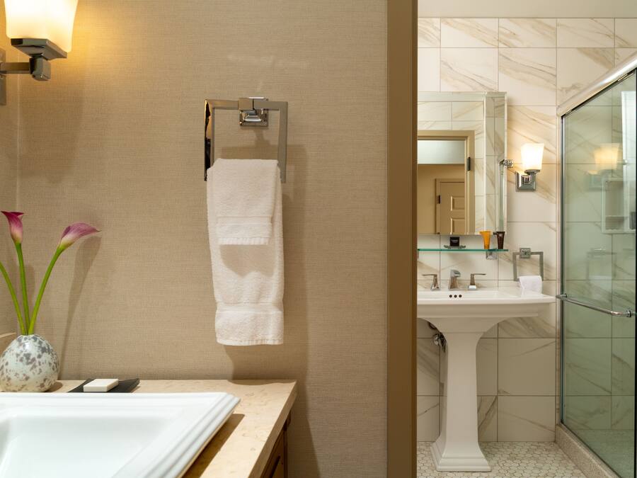 Un baño con lavabo, espejo y cabina de ducha de vidrio.