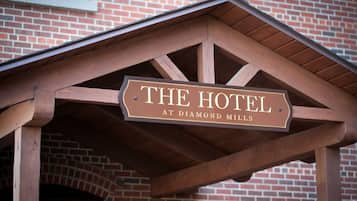 Un letrero de madera con el texto 'THE HOTEL AT DIAMOND MILLS'.