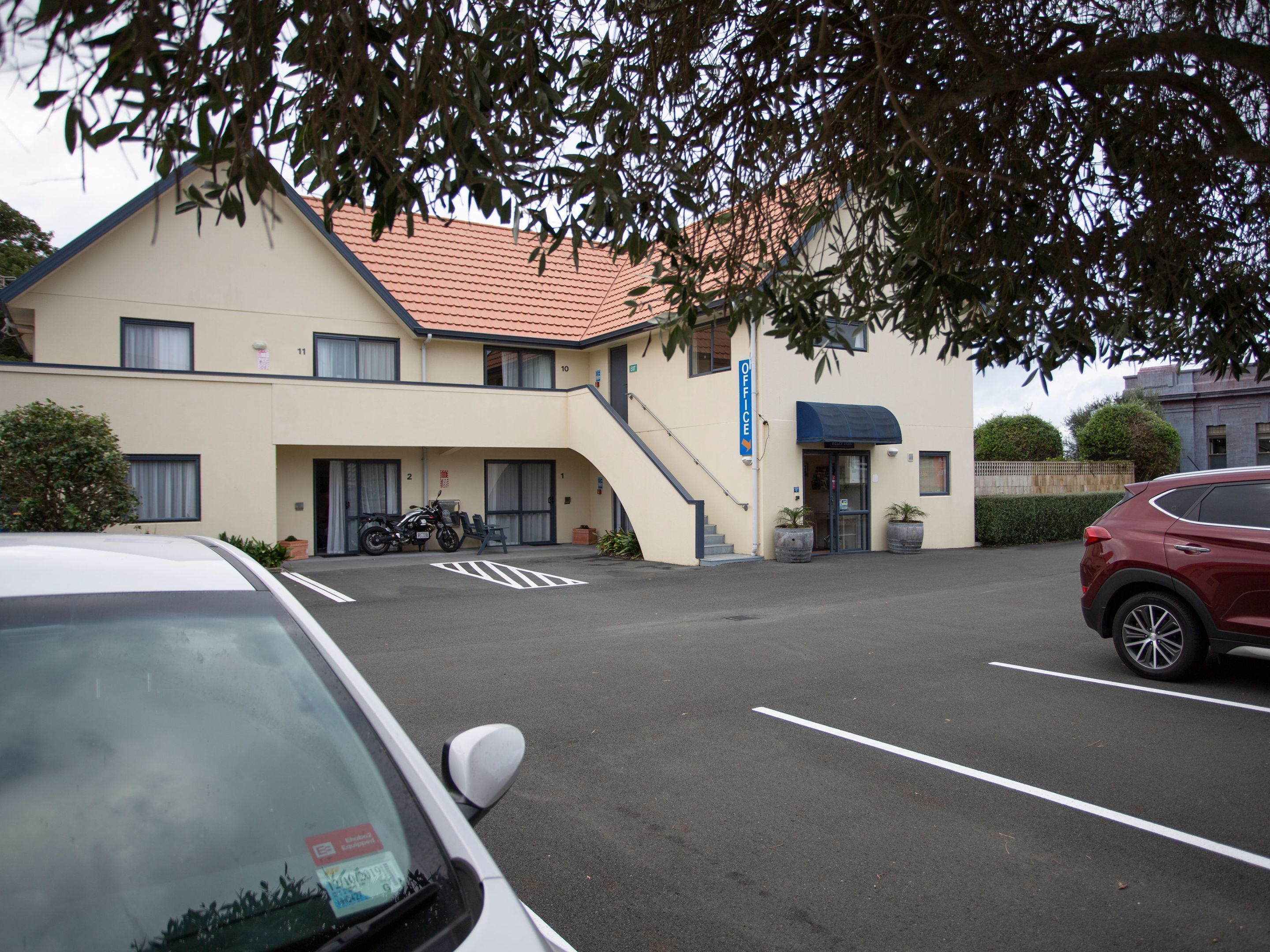 Ein Gebäude mit einem Schild, auf dem „OFFICE“ steht, und ein Parkplatz mit Autos.