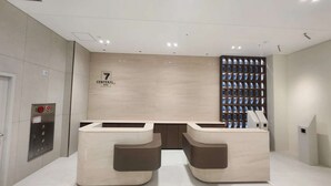 A modern hotel reception area with a minimalist design, featuring a central desk and two symmetrical seating areas. - Central Seven Hotel by Kwon Busan Seomyeon (Busan)