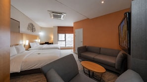 A hotel room with two beds, a sofa, a small table, and a TV. - Central Seven Hotel by Kwon Busan Seomyeon (Busan)