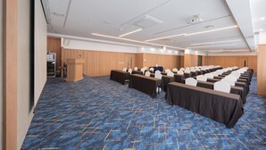A conference room with rows of tables, chairs, and a podium. - Central Seven Hotel by Kwon Busan Seomyeon (Busan)