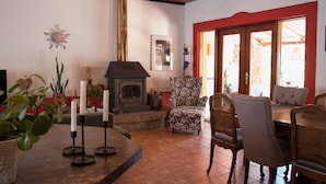 Un salon chaleureux avec une cheminée, des sièges confortables et un coin repas.