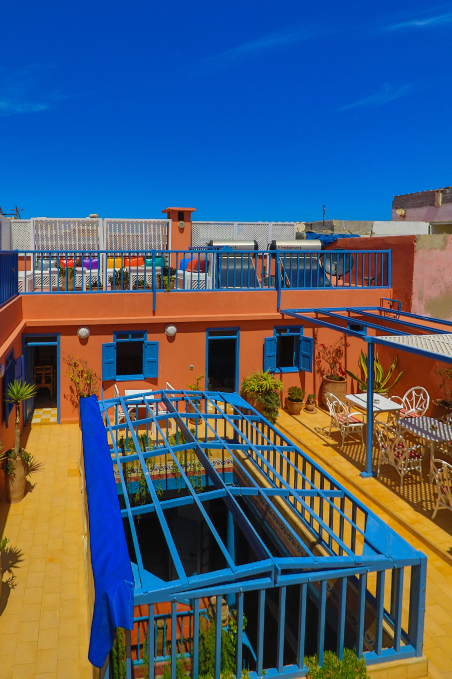 A multi-level building with balconies, outdoor seating, and a blue railing structure.