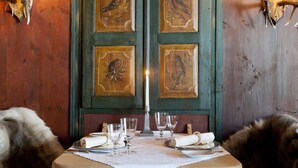 A wooden table with a white tablecloth, candles, and glasses. - House of Hütter - Wachtelhof Hotel & Spa (Maria Alm am Steinernen Meer)