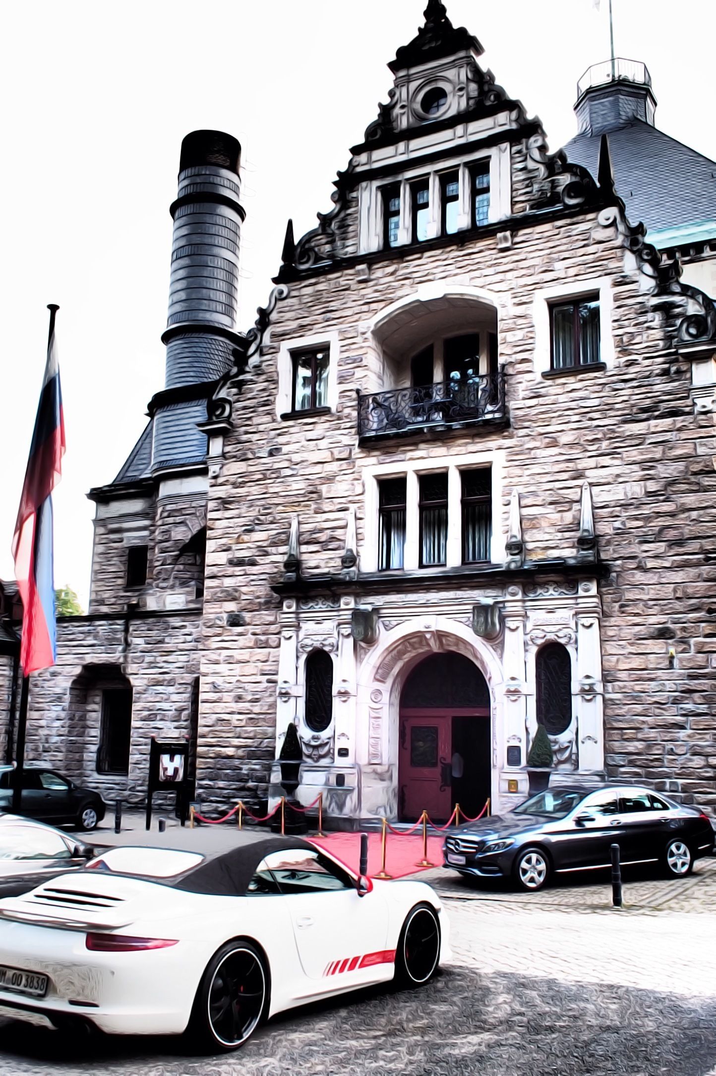 A stone building with a turret and a red entrance.