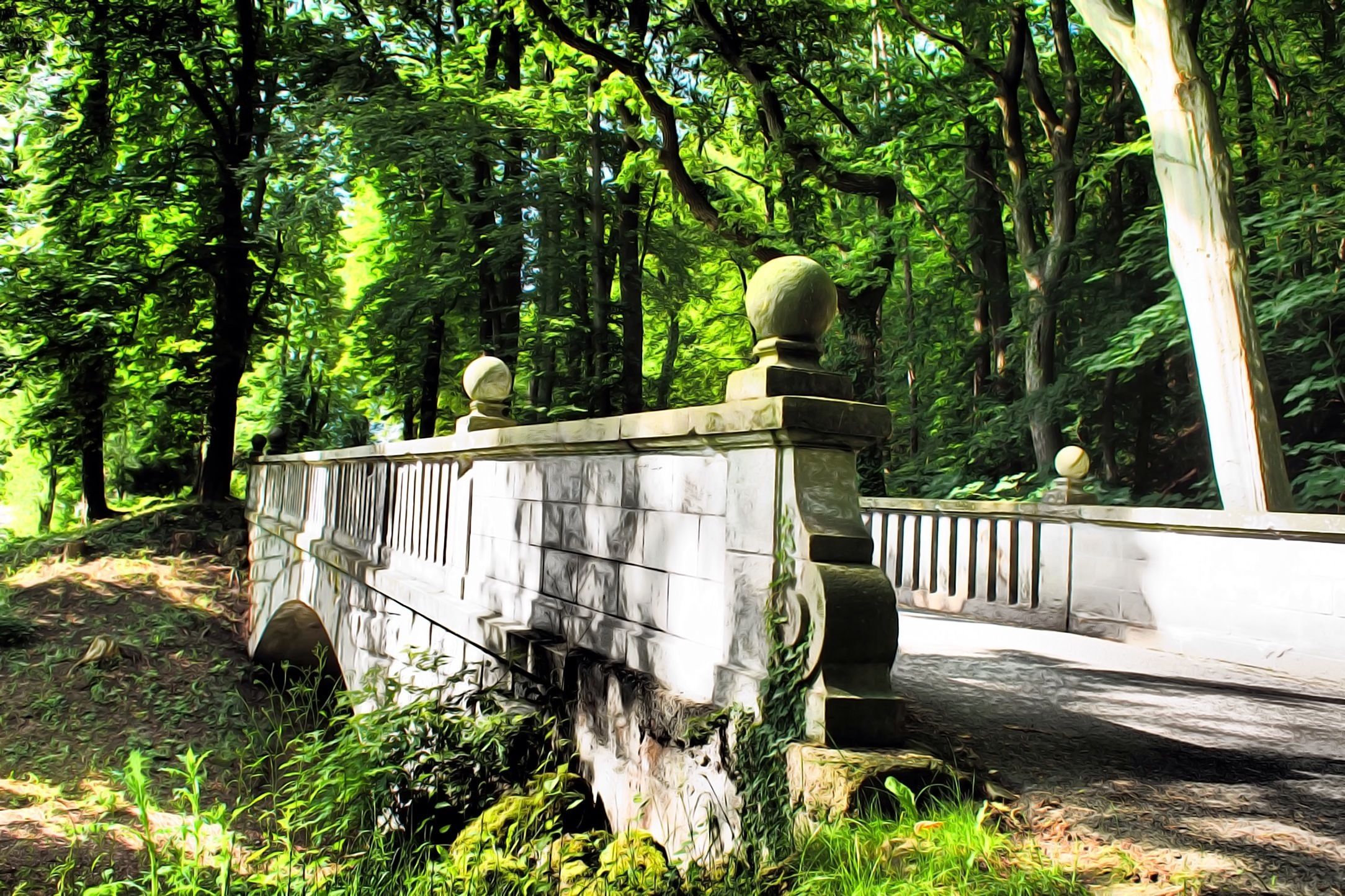 A stone bridge with a balustrade, surrounded by dense green foliage.