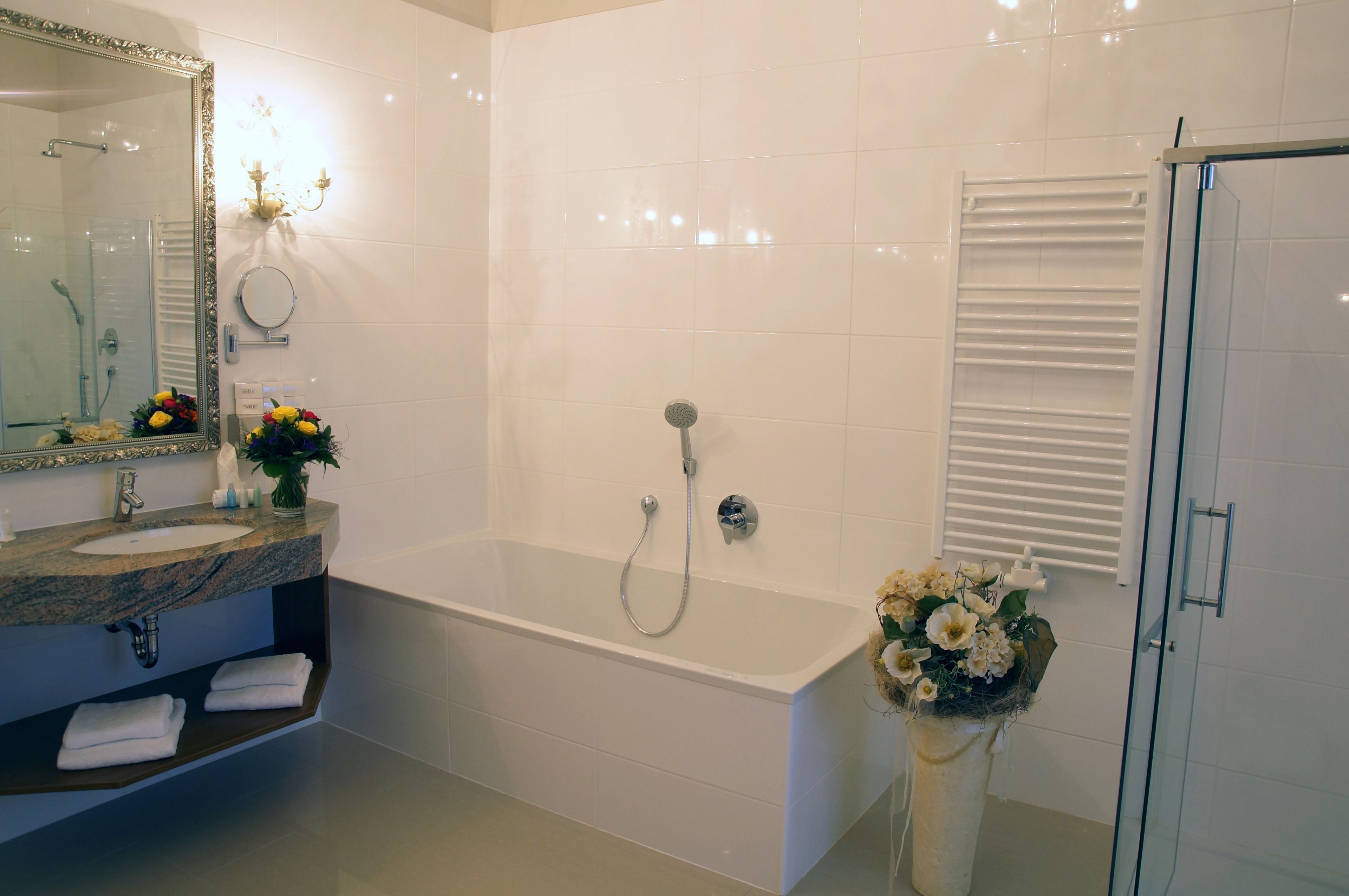 Un baño moderno con una bañera grande, un tocador con espejo y una ducha.