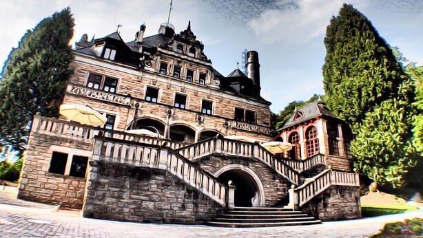 Un grand bâtiment historique à plusieurs niveaux, doté d’un escalier imposant et d’une petite tour.
