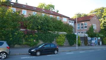 A residential street with a row of houses, a parked car, and a bicycle.