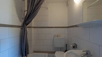 A bathroom with a bathtub, toilet, and sink.