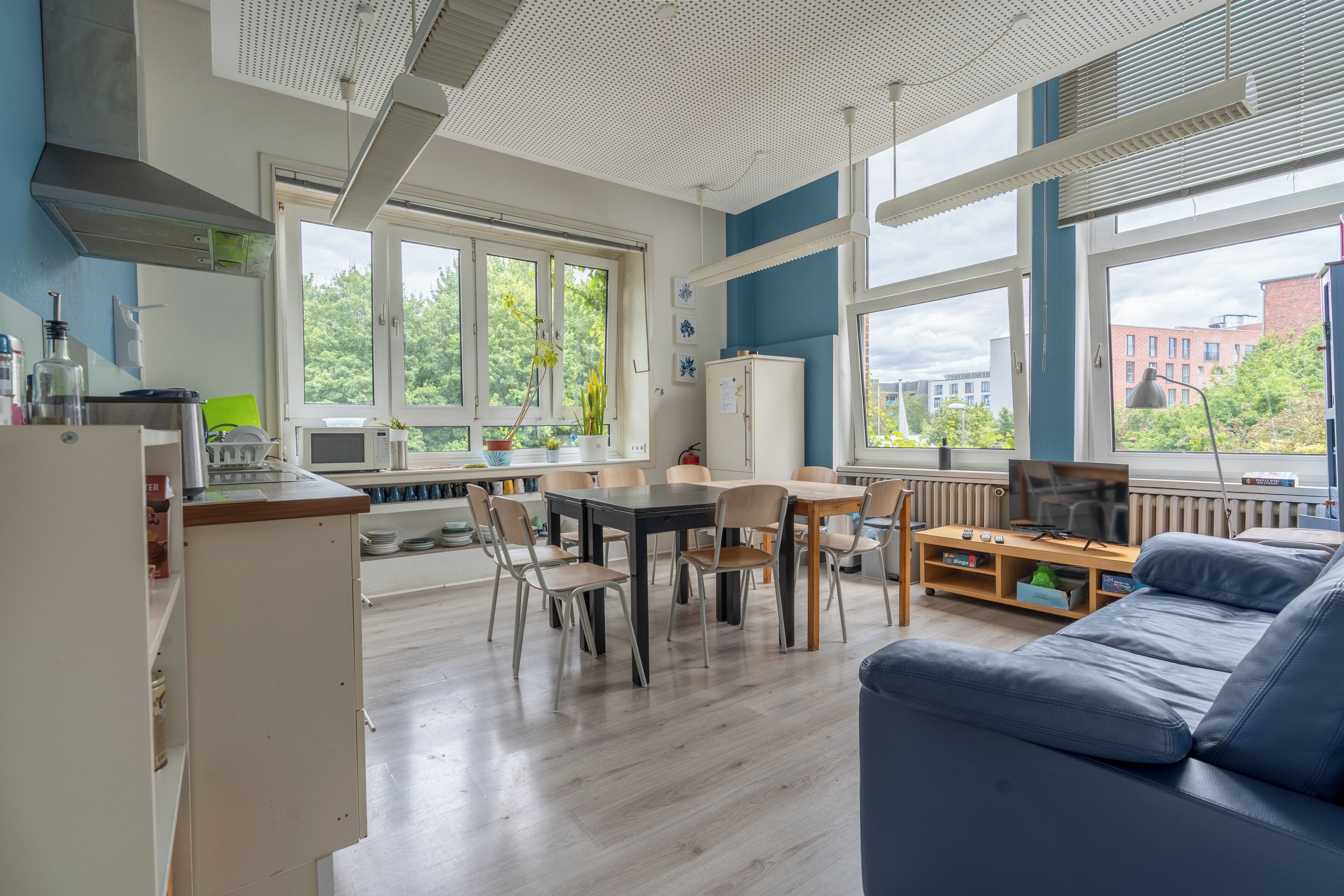 Eine moderne Küche mit Essbereich, großen Fenstern und Blick ins Freie.
