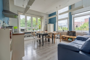 A modern kitchen with a dining area, large windows, and a view of the outside. - Flensbed Hotel & Hostel (Flensburg)