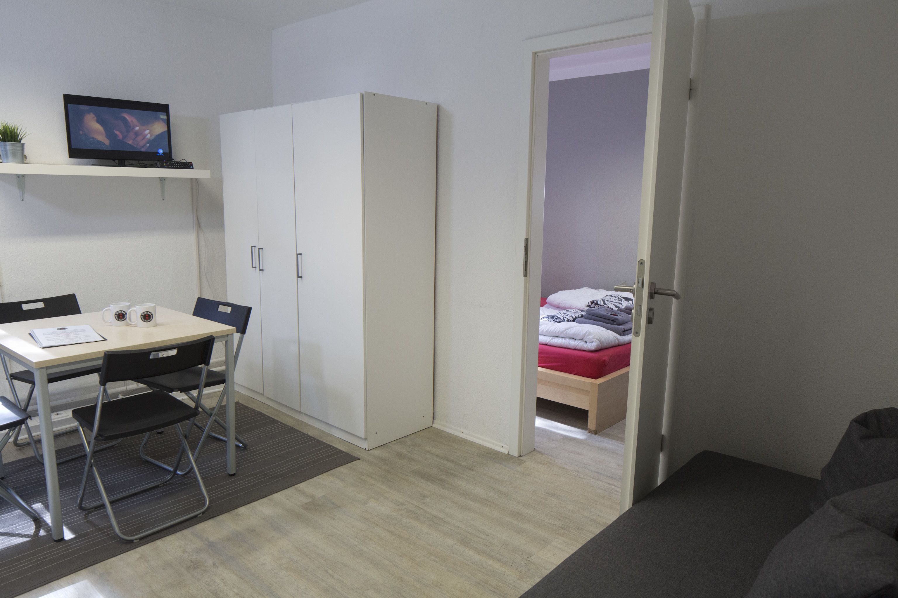 A compact room with a desk, chair, and a bed.