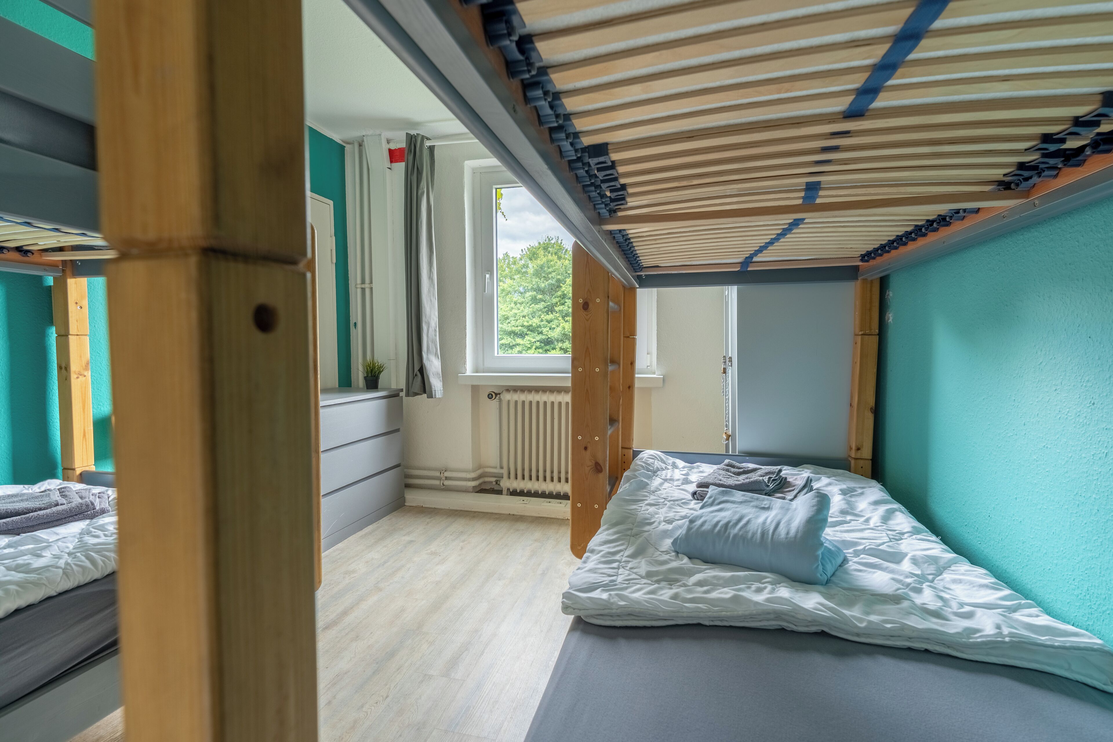 A room with a bed, a window, and a radiator.