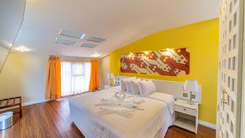 A hotel room with a large bed, a nightstand, a wall-mounted lamp, and a decorative wall piece.