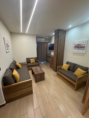 Suite, 2 chambres, 2 salles de bains, vue partielle sur l'océan | Aire de séjour | Téléviseur à écran plat