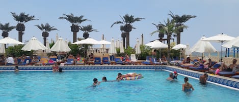 Een seizoensgebonden buitenzwembad, parasols voor strand/zwembad