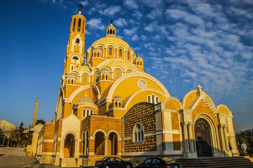 A large yellow church with a tall bell tower and multiple domes.