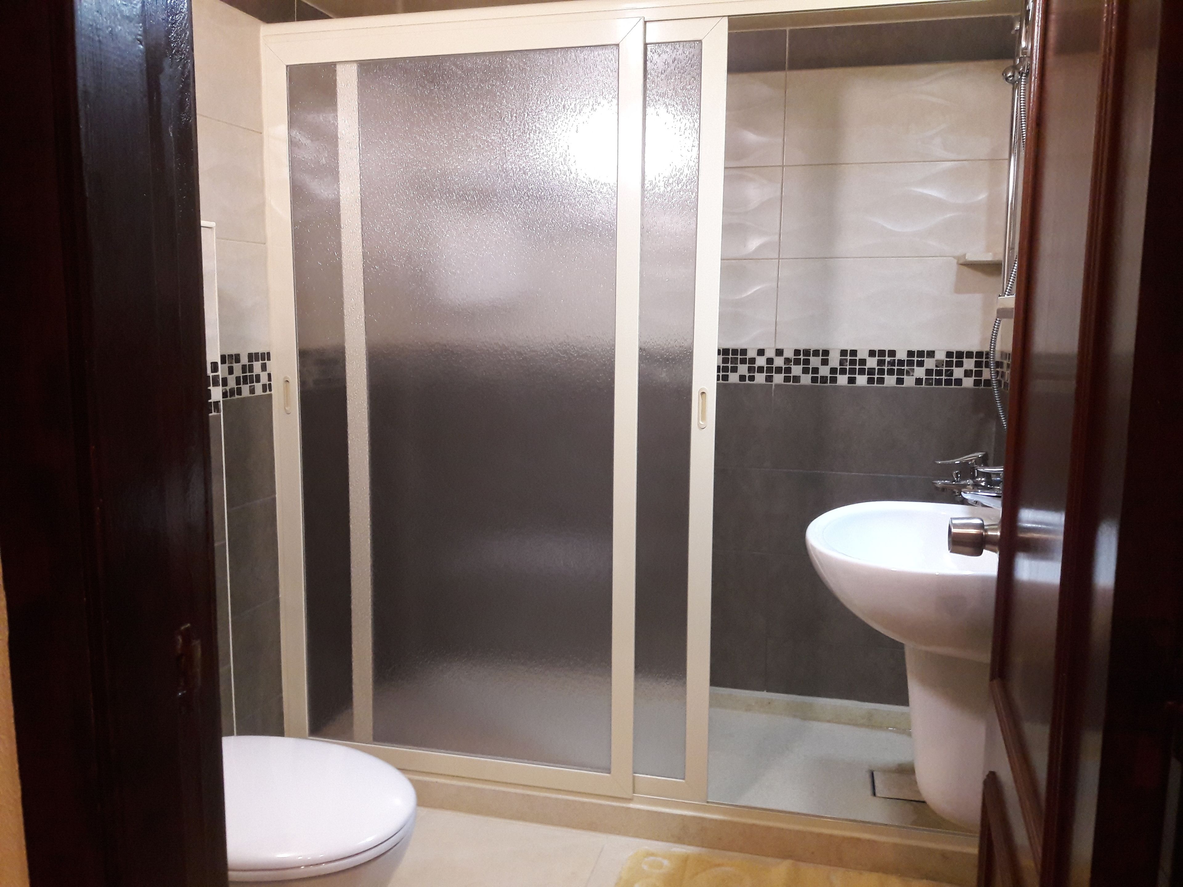 Un baño con inodoro, ducha y lavamanos.