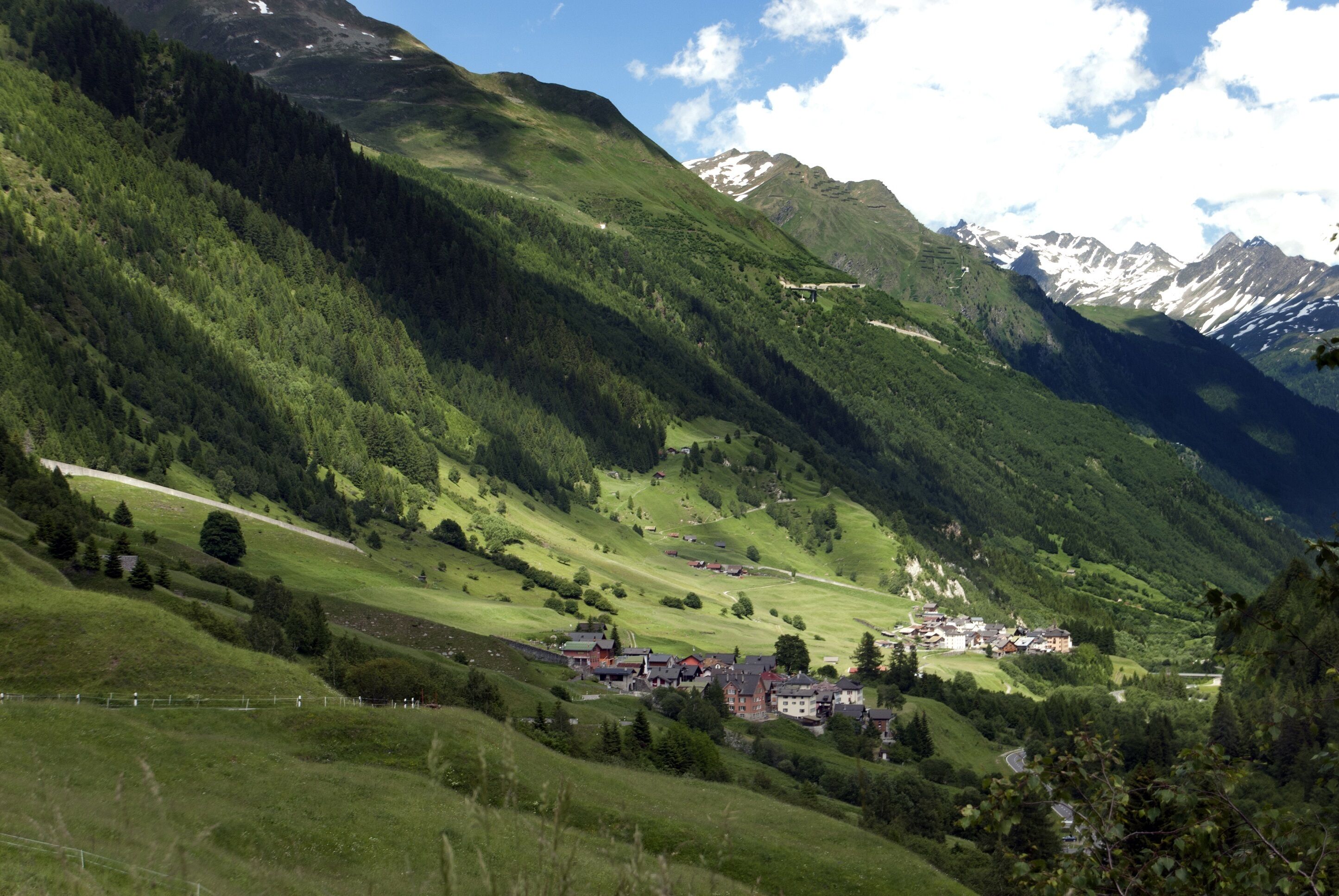 Eine gebirgige Landschaft mit einem Dorf, eingebettet in ein Tal.