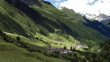 Eine gebirgige Landschaft mit einem Dorf, eingebettet in ein Tal.