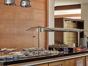 A buffet setup with various food items and a glass display case. - Atlantica Grand Mediterraneo Resort - Adults Only (Corfu)