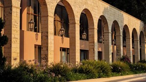 A building with a row of arched windows and a series of hanging lanterns. - Atlantica Grand Mediterraneo Resort - Adults Only (Corfu)