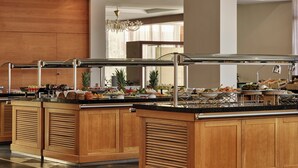 A buffet area with wooden cabinets and a variety of food items. - Atlantica Grand Mediterraneo Resort - Adults Only (Corfu)