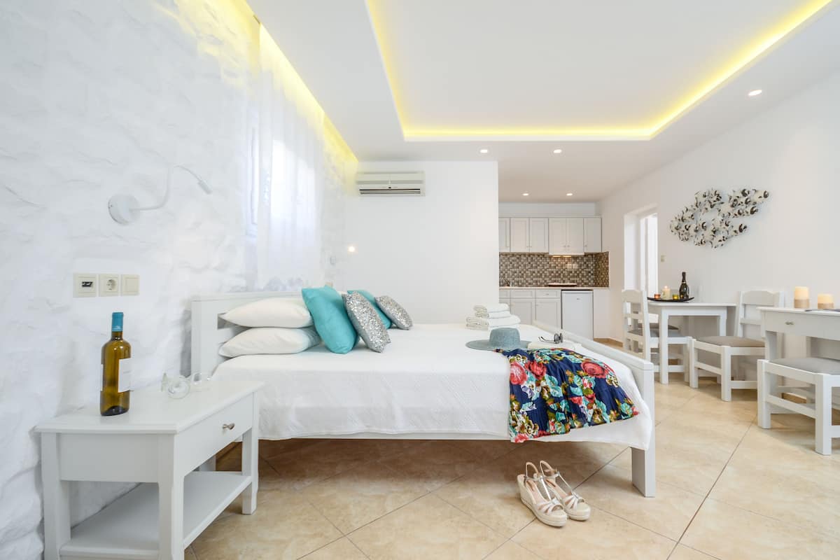 A modern bedroom with a bed, bedside table, and a small desk area.