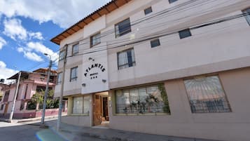 A two-story building with a sign reading "Atlantis Hostel".