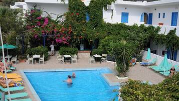 Una piscina al aire libre de temporada, sombrillas
