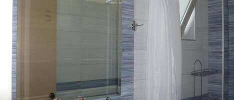 A bathroom with a glass shelf, a shower, and a mirror.
