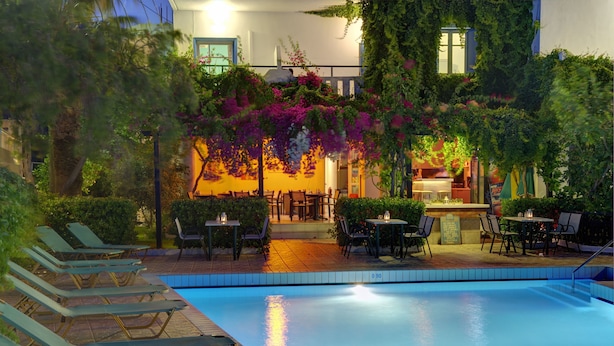 A poolside area with lounge chairs, tables, and a bar. - Costas & Chrysoula (Agios Vasileios)
