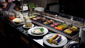 A buffet setup with various food items and condiments. - Wärdshuset C. Dickens (Fagersta)