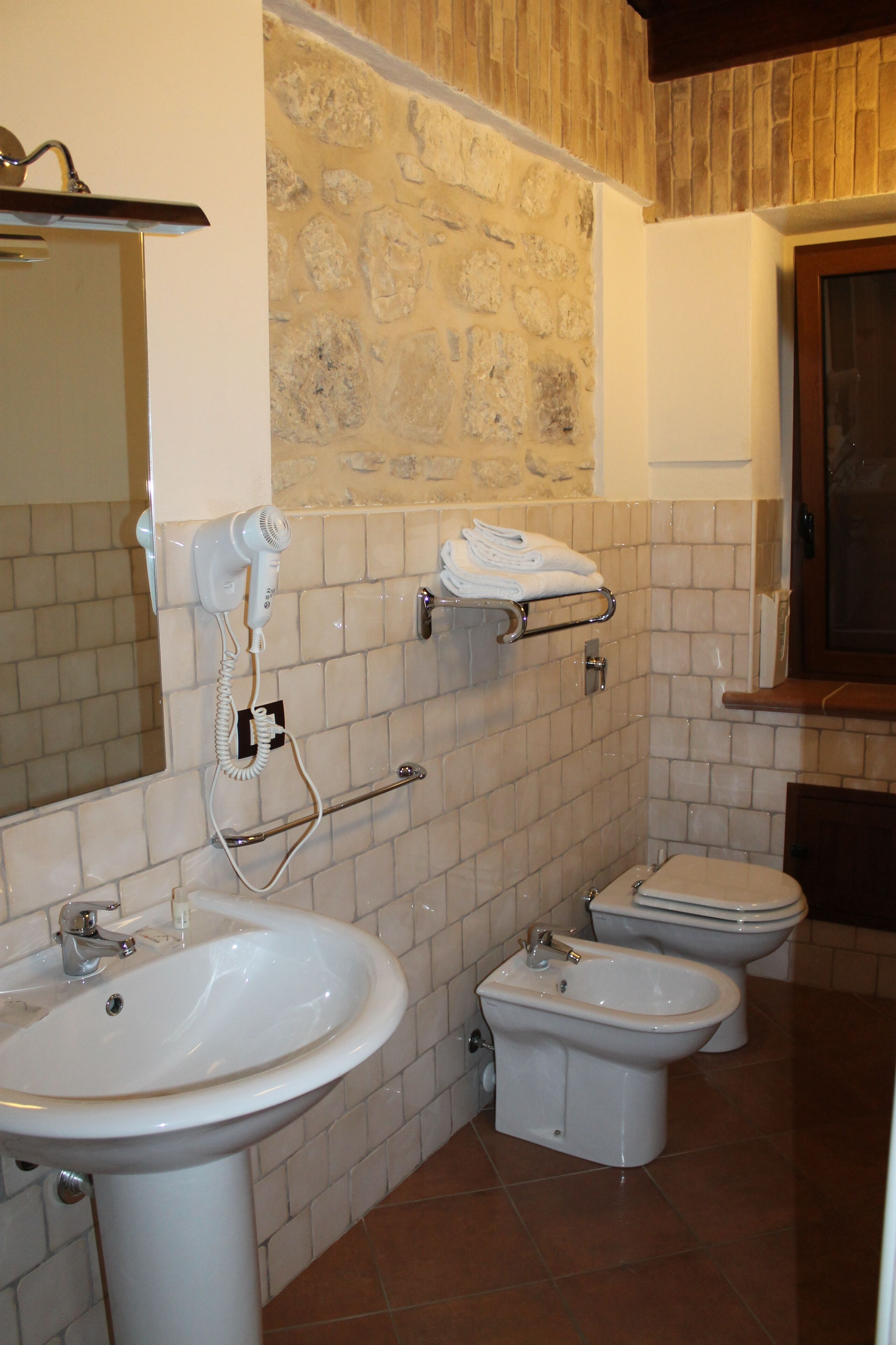 Casa de banho com lavatório, bidé e porta-toalhas.