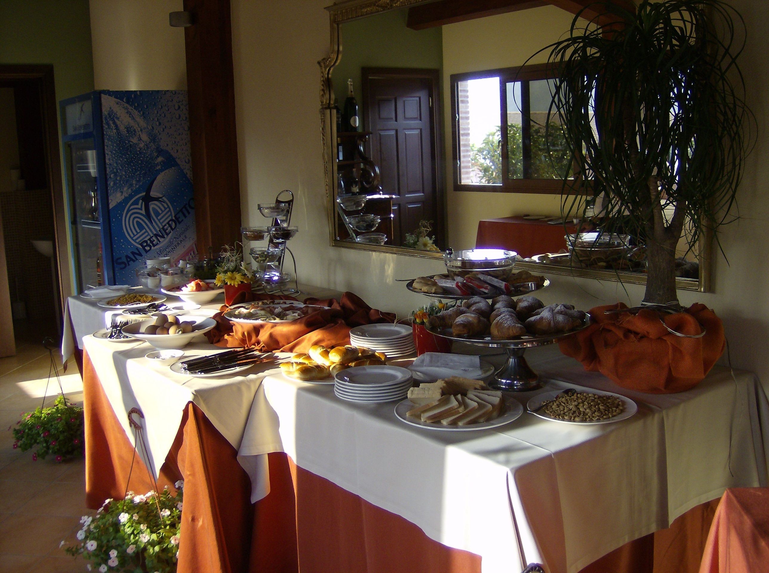 Ein Buffet mit verschiedenen Speisen und ein Spiegel, der den Raum widerspiegelt.