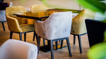 Un coin repas avec une table rectangulaire et quatre chaises, dont une est blanche.