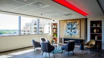 A modern interior with a large window, a fireplace, and a view of a building.