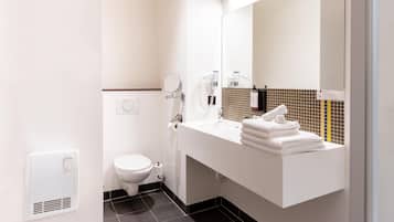 A modern bathroom with a white sink, a mirror, and a towel rack.