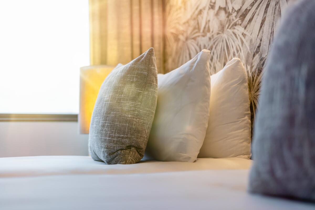 A bed with pillows and a candle.