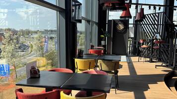 Enjoy casual dining with a view of the city from this open-plan space featuring a staircase and large windows.